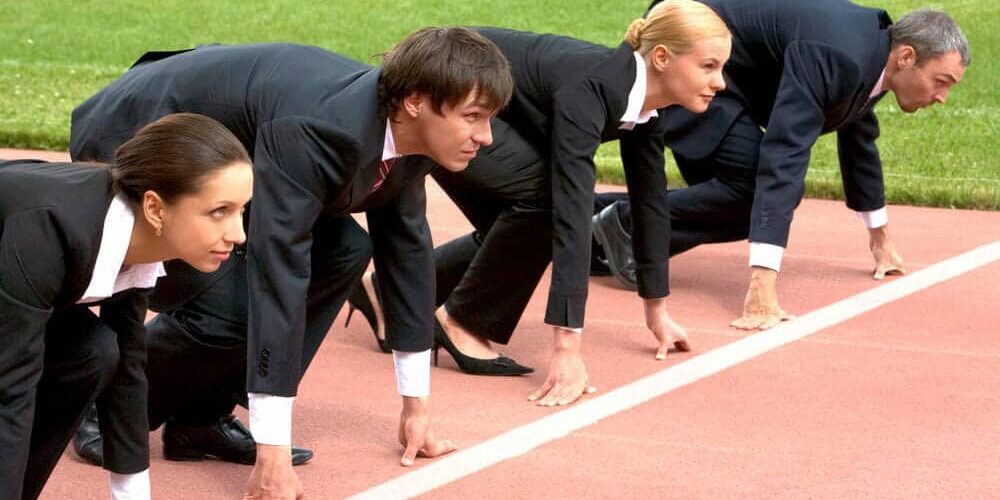Business people lined up at track starting line