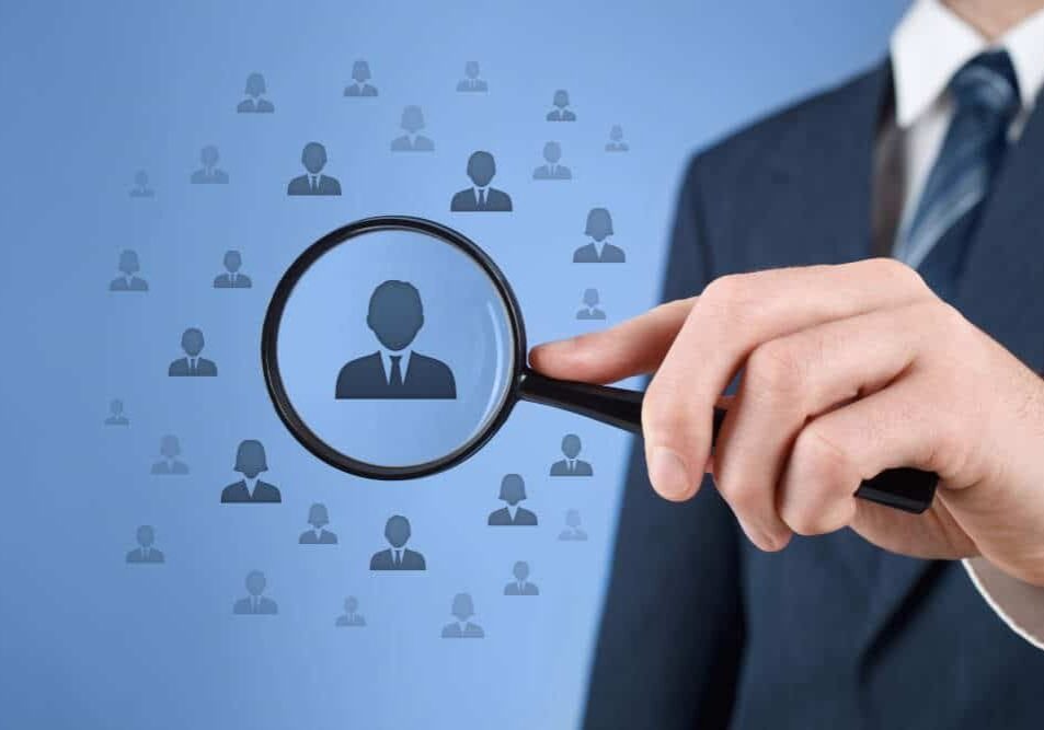 Employee singled out from crowd with magnifying glass