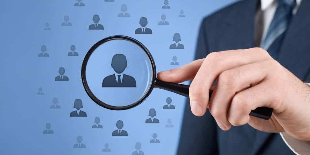Employee singled out from crowd with magnifying glass