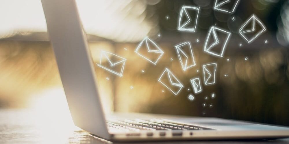 Side view of laptop with e-mail icons