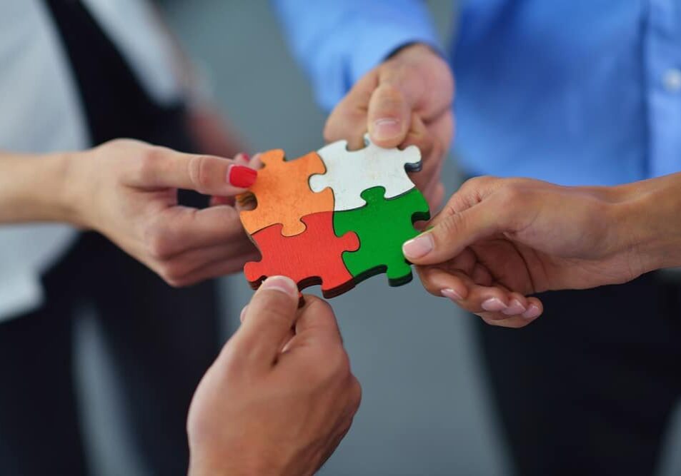 Team holding puzzle pieces together