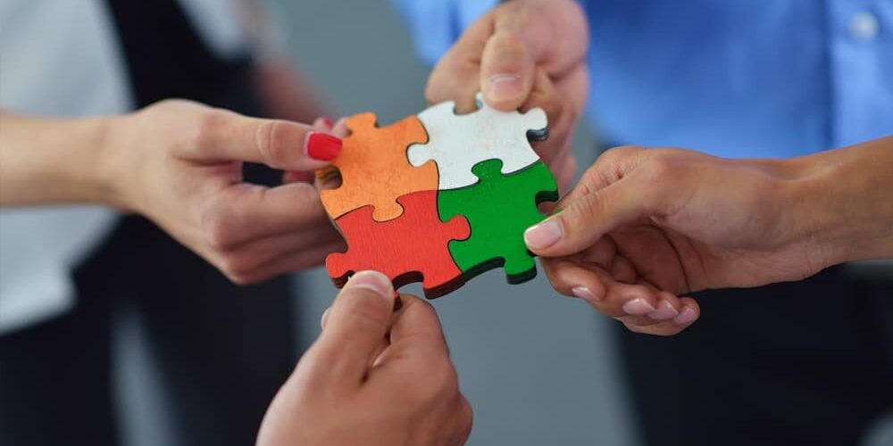 Team holding puzzle pieces together