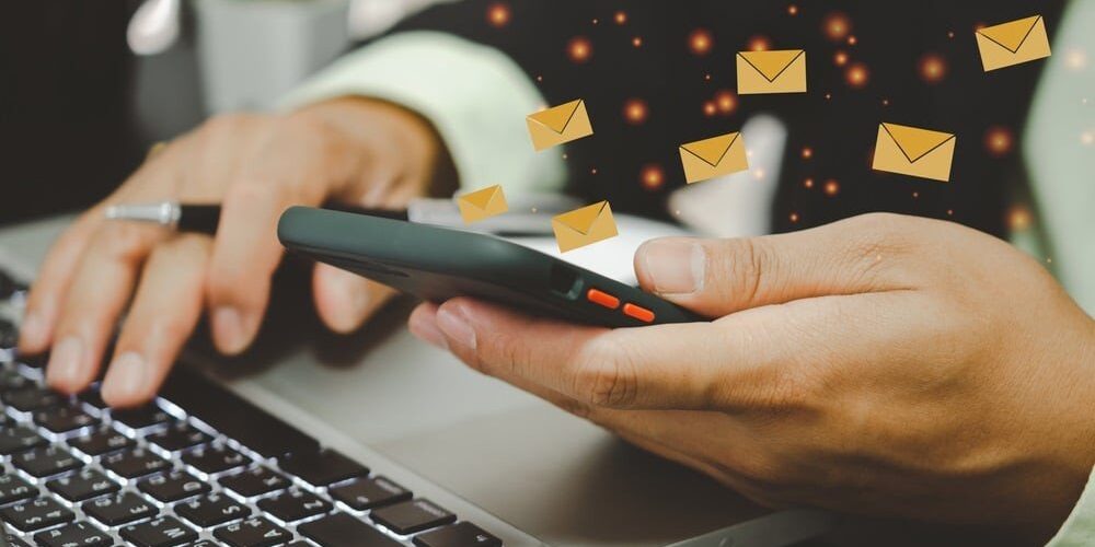 Close-up man holding a cell phone an icon email message